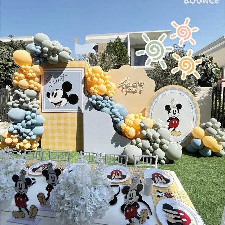 Mickey themed birthday setup with blue and yellow balloons and personalised signage