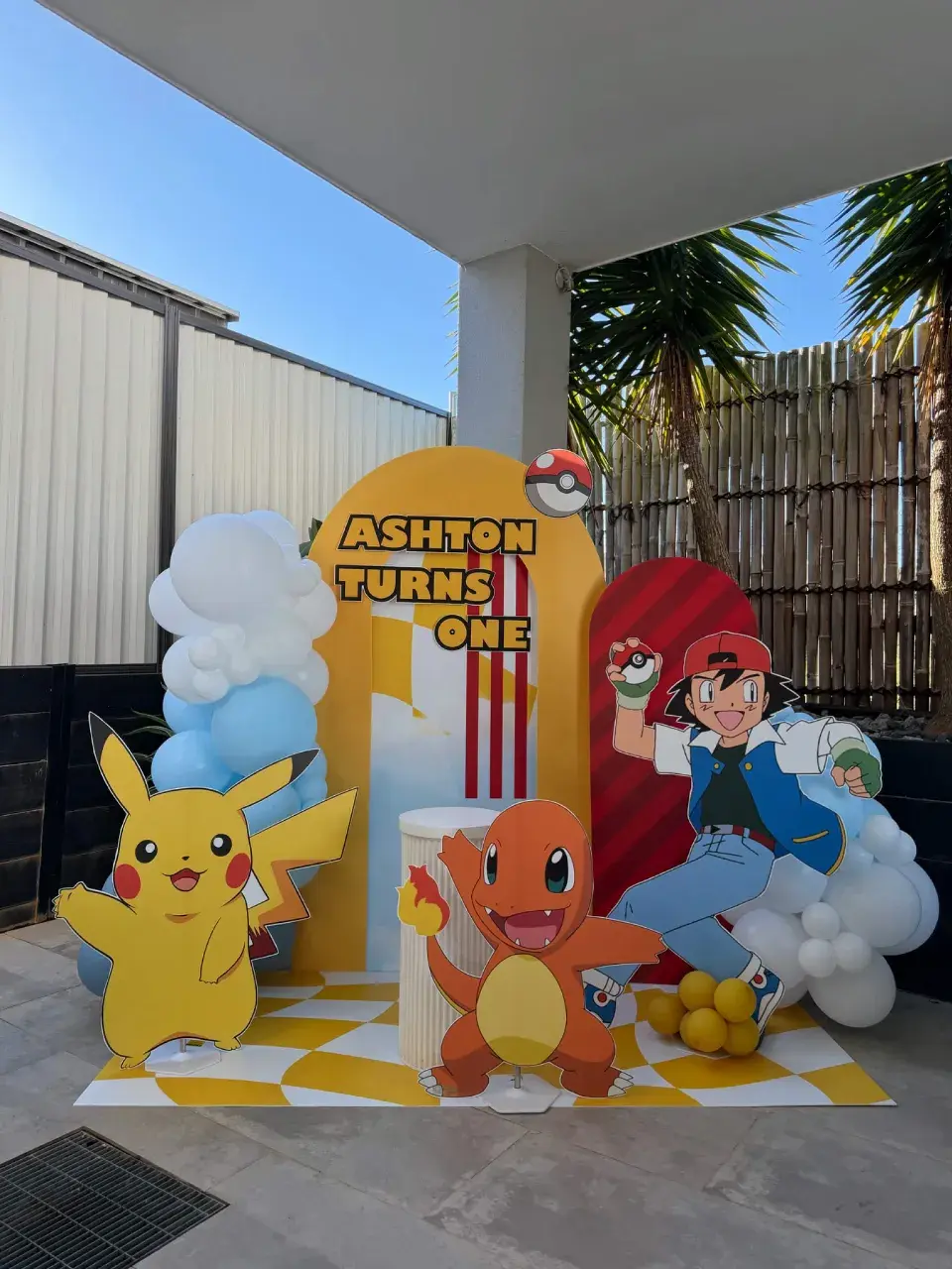 Pokemon themed birthday backdrop with balloons, character cut-outs and a personalised name sign