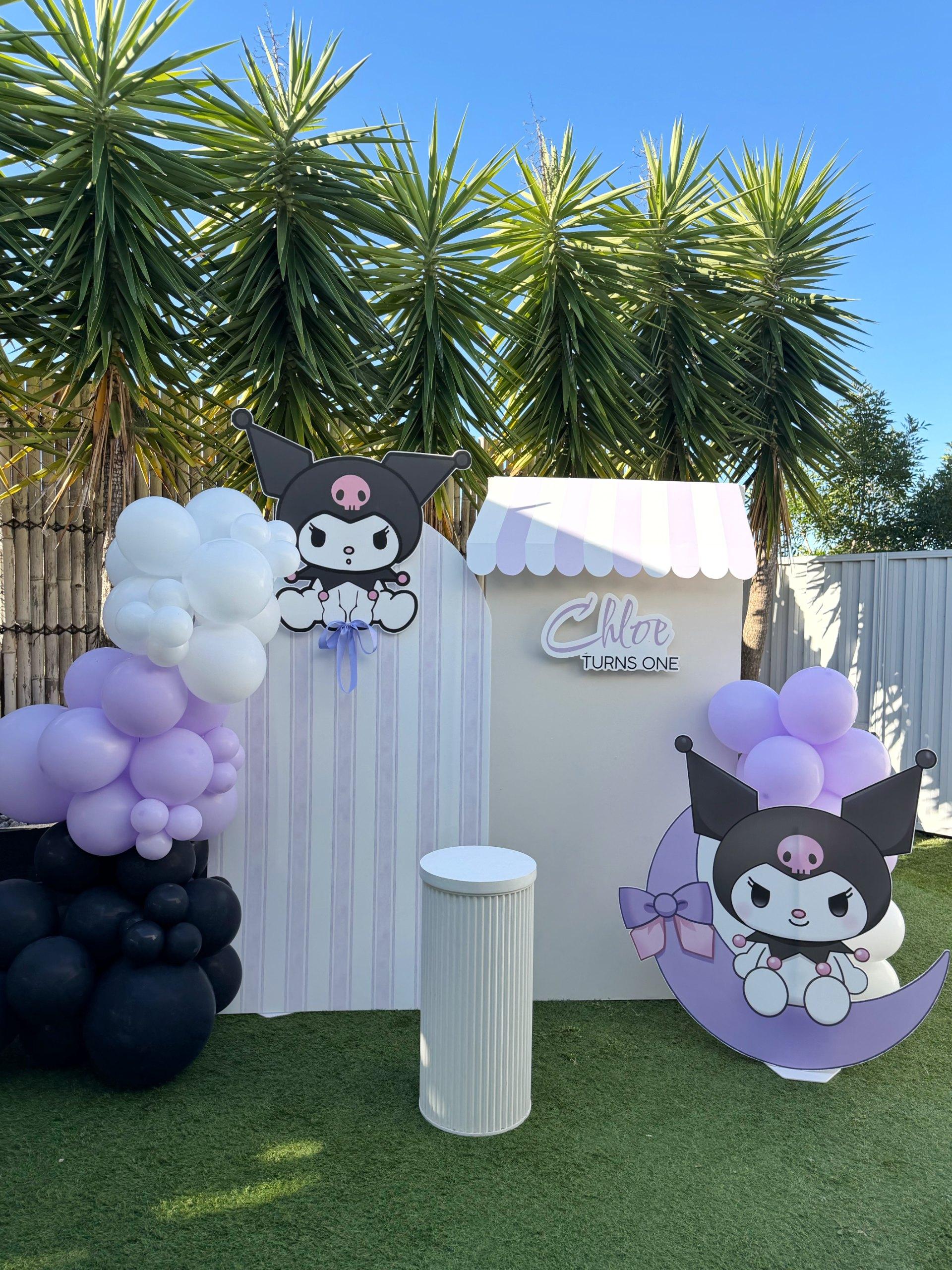 Kuromi birthday backdrop with black, lavender and white balloons, character cut-outs and a Chloe turns one sign